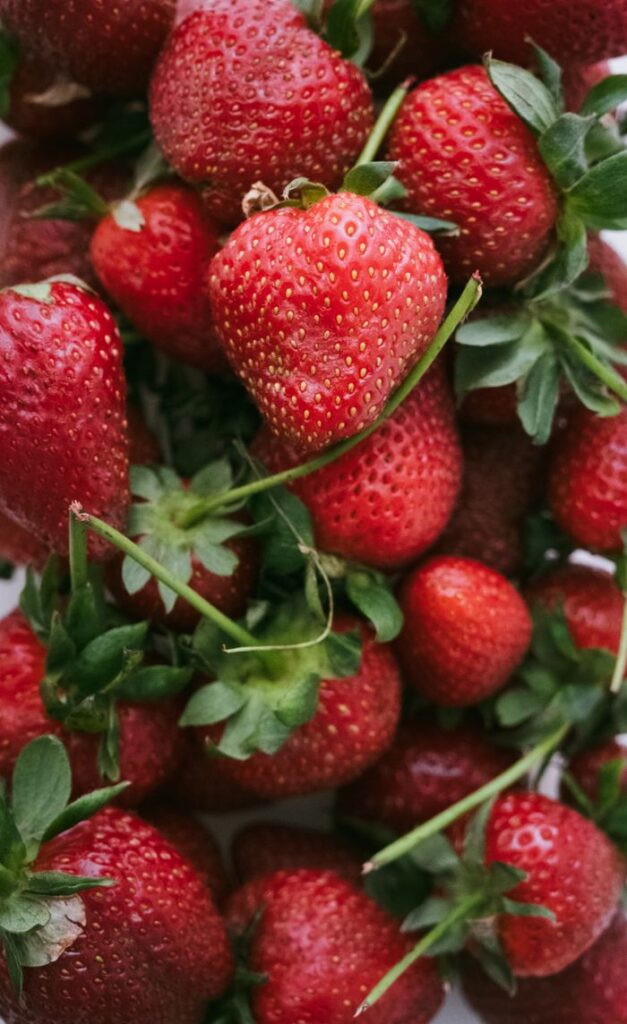 Vibrant fresh strawberries close-up with green leaves, capturing the essence of summer.