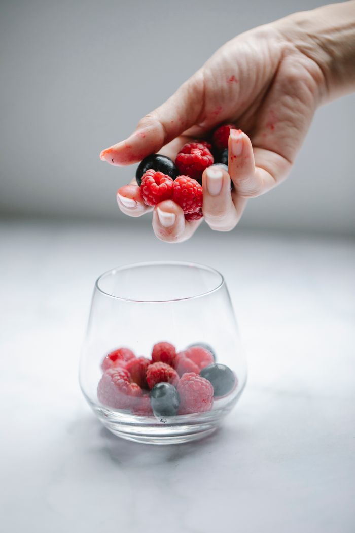 Crafting Captivating Headlines: Your awesome post title goes here Crop anonymous female putting tasty raspberries and blueberries into glassware placed on white table